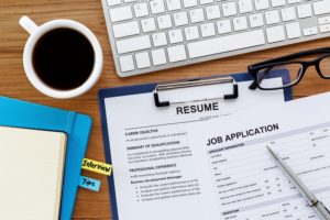 Conducting a Job search with resume and job application on computer work table