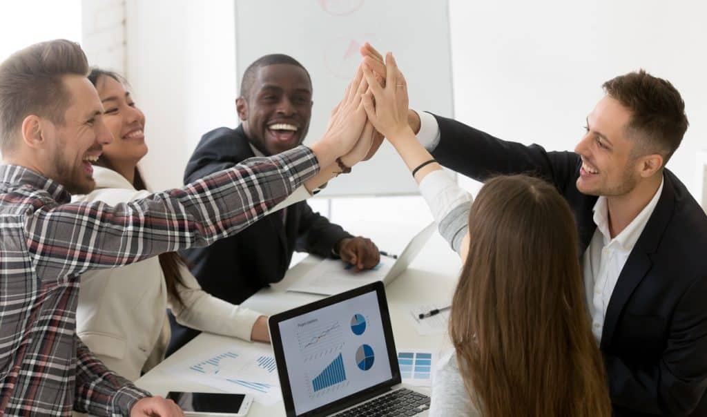 Excited diverse colleagues giving high five for performance, goal achievement