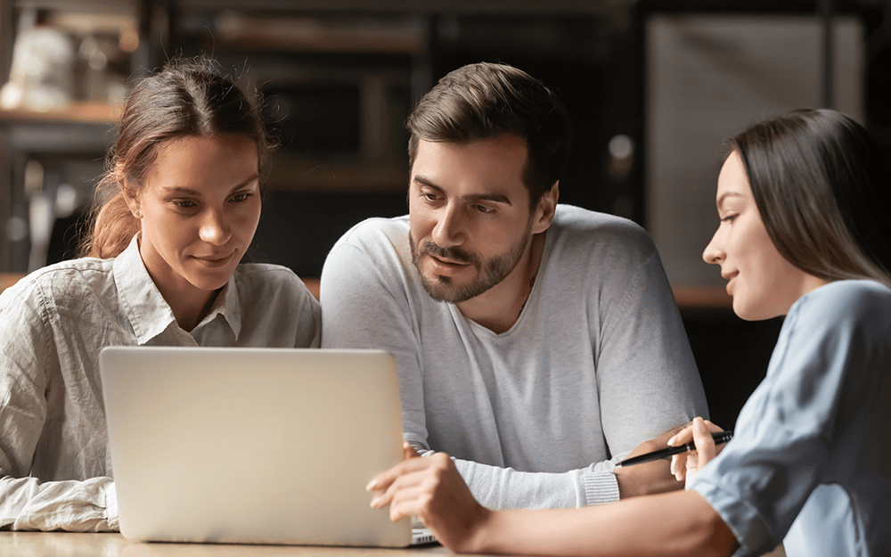 man and two women looking at the computer screen