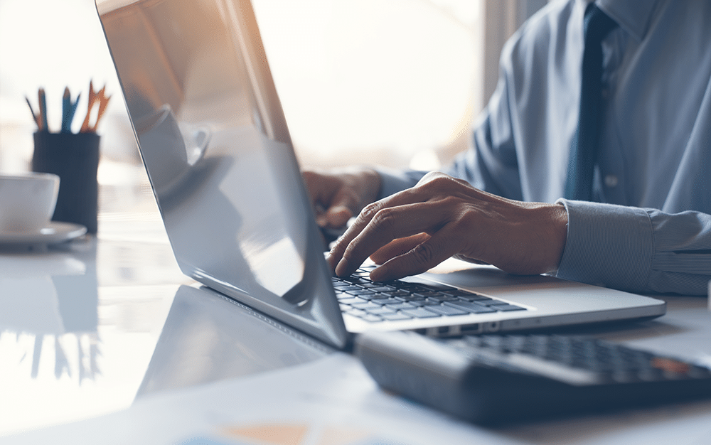 man typing on his computer