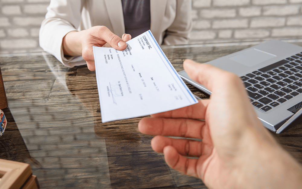 woman handing over a man a paycheck